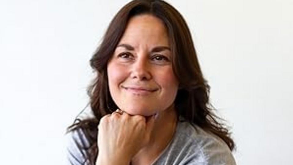 headshot of 40-something brunette leaning her head on her fist.