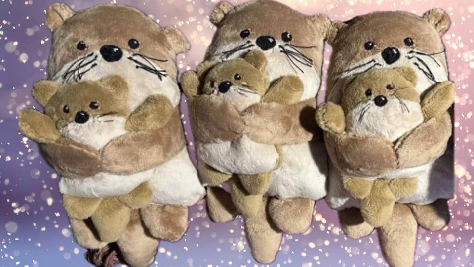 Cute handmade stuffed momma otters holding baby otters.