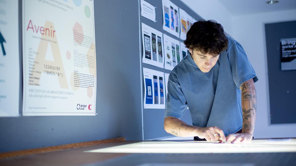 Graphic Design student working on light table in low lighting