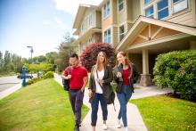Three students walk together outside of VIU Residences