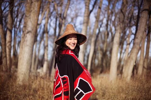 Marion in front of winter trees wearing traditional clothing