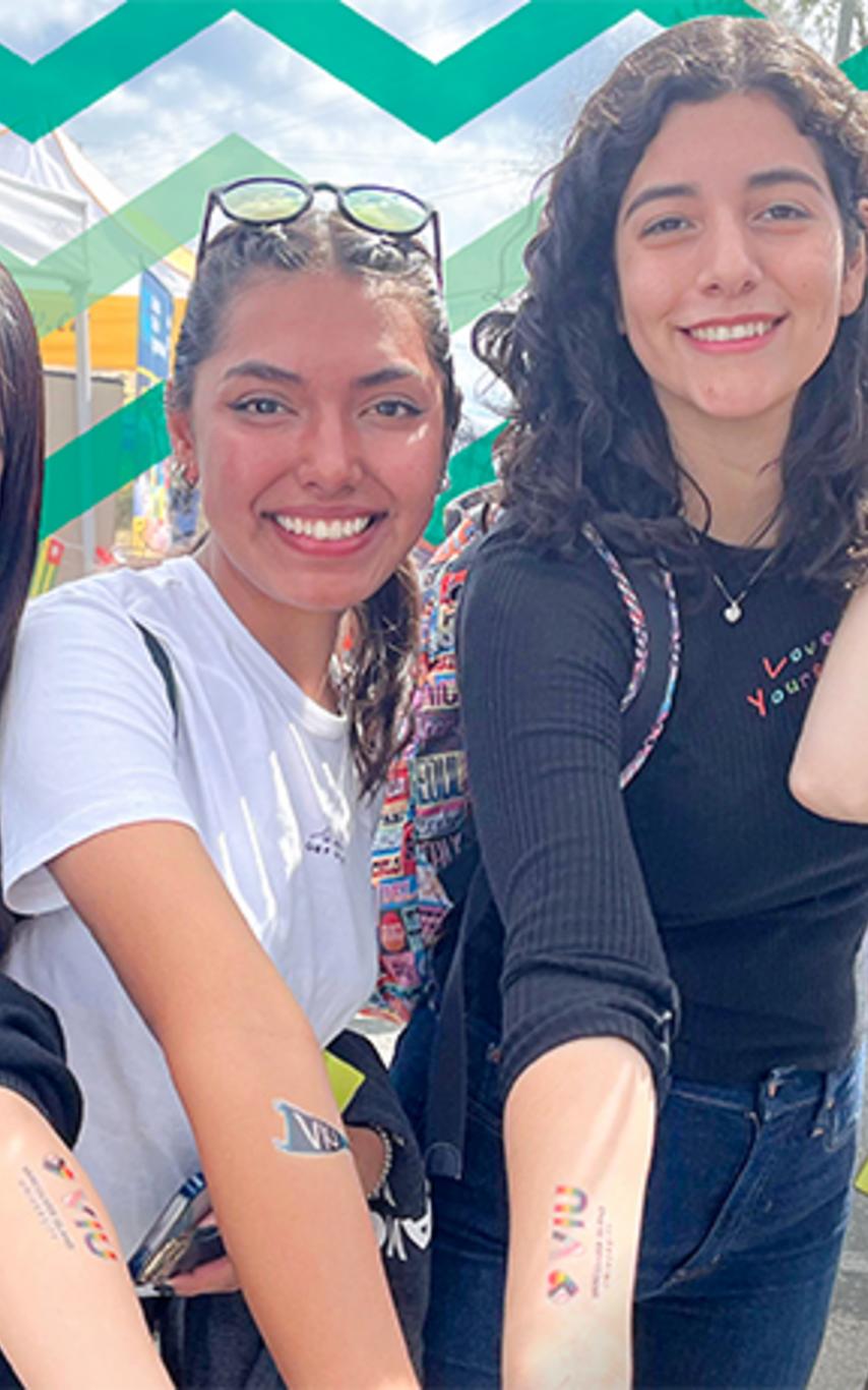 Students display their VIU tattoos with a RockVIU logo in the corner